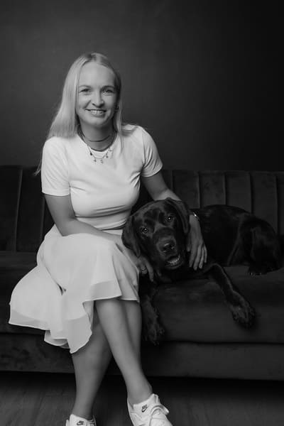 Kim Kurowski Inhaberin von Leinebraut GmbH in Hannover sitzt mit schwarzem Hund auf einem Sofa